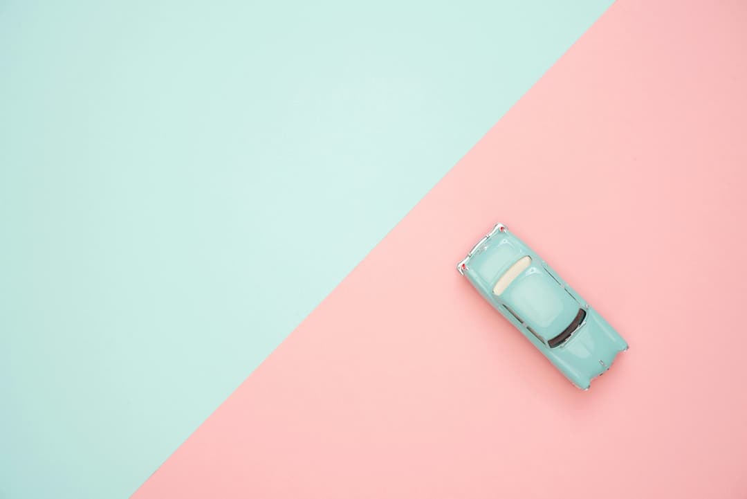 Prowall Free Wallpaper | Toy car on a pastel pink and blue background, representing simplicity and retro design.