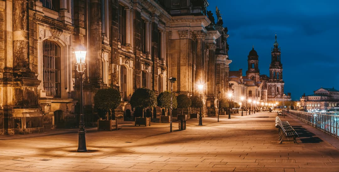 Prowall Free Wallpaper | Beautiful illuminated historical buildings and lampposts in European cityscape at dusk.
