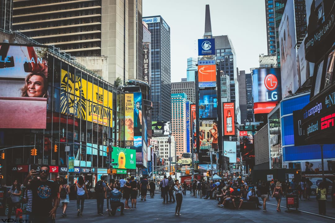 Prowall Free Wallpaper | Bustling daytime view of Times Square with crowds, skyscrapers, and iconic billboards in New York City.