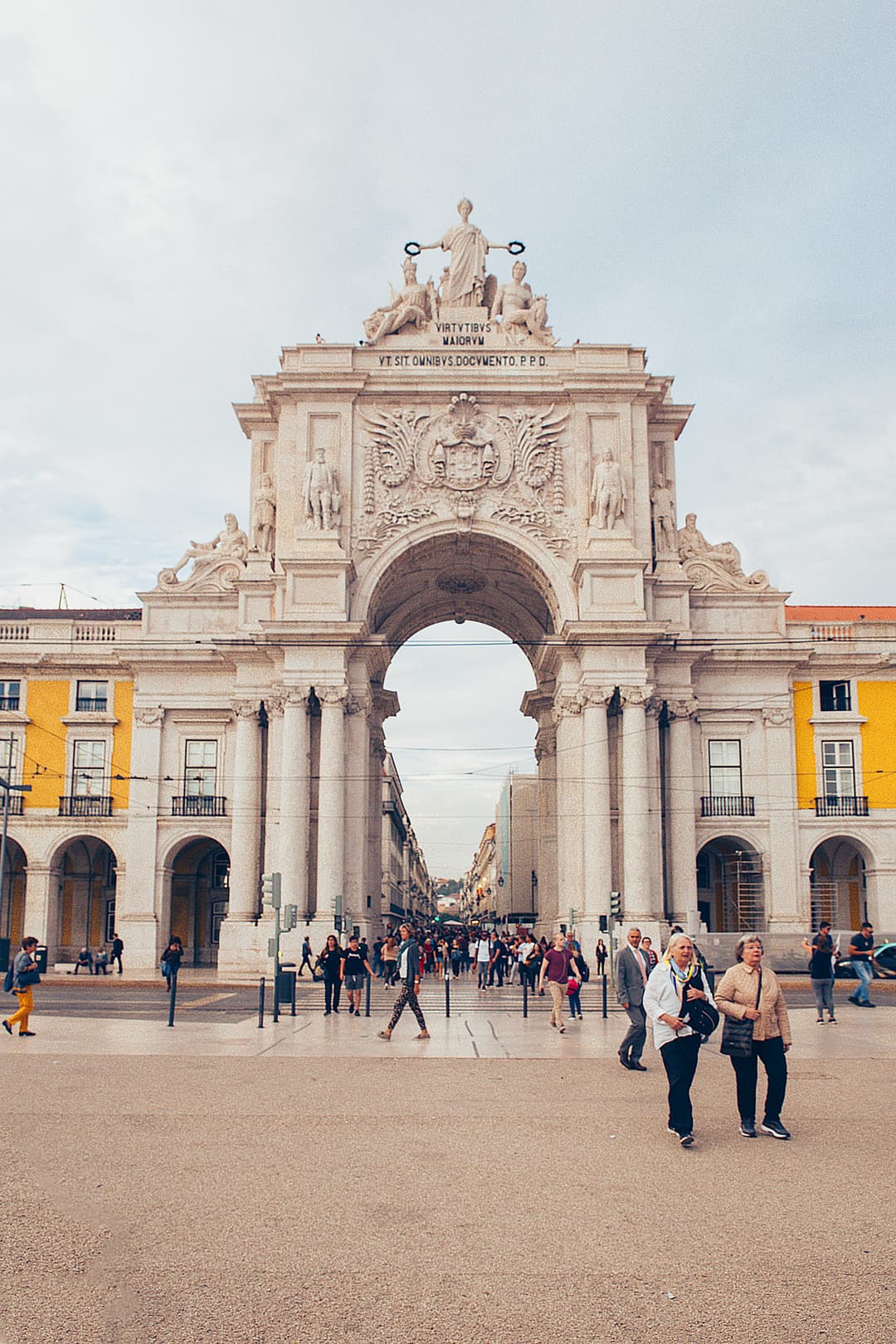 Prowall Free Wallpaper | A scenic view of the iconic Rua Augusta Arch in Lisbon, Portugal with people strolling in the plaza.