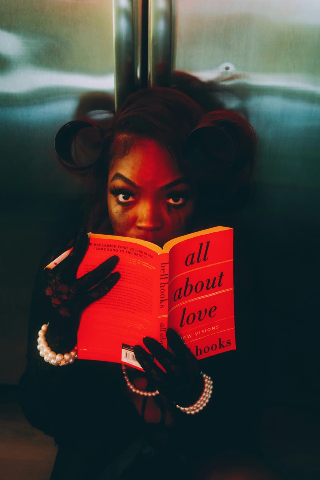Prowall Free Wallpaper | Artistic portrait of woman reading 'All About Love' with dramatic lighting.