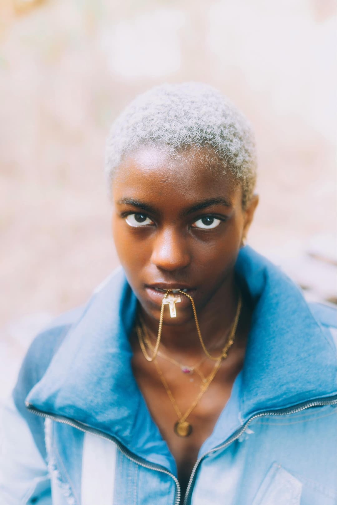 Prowall Free Wallpaper | Striking portrait of a fashionable woman with afro hair, wearing denim and gold jewelry.
