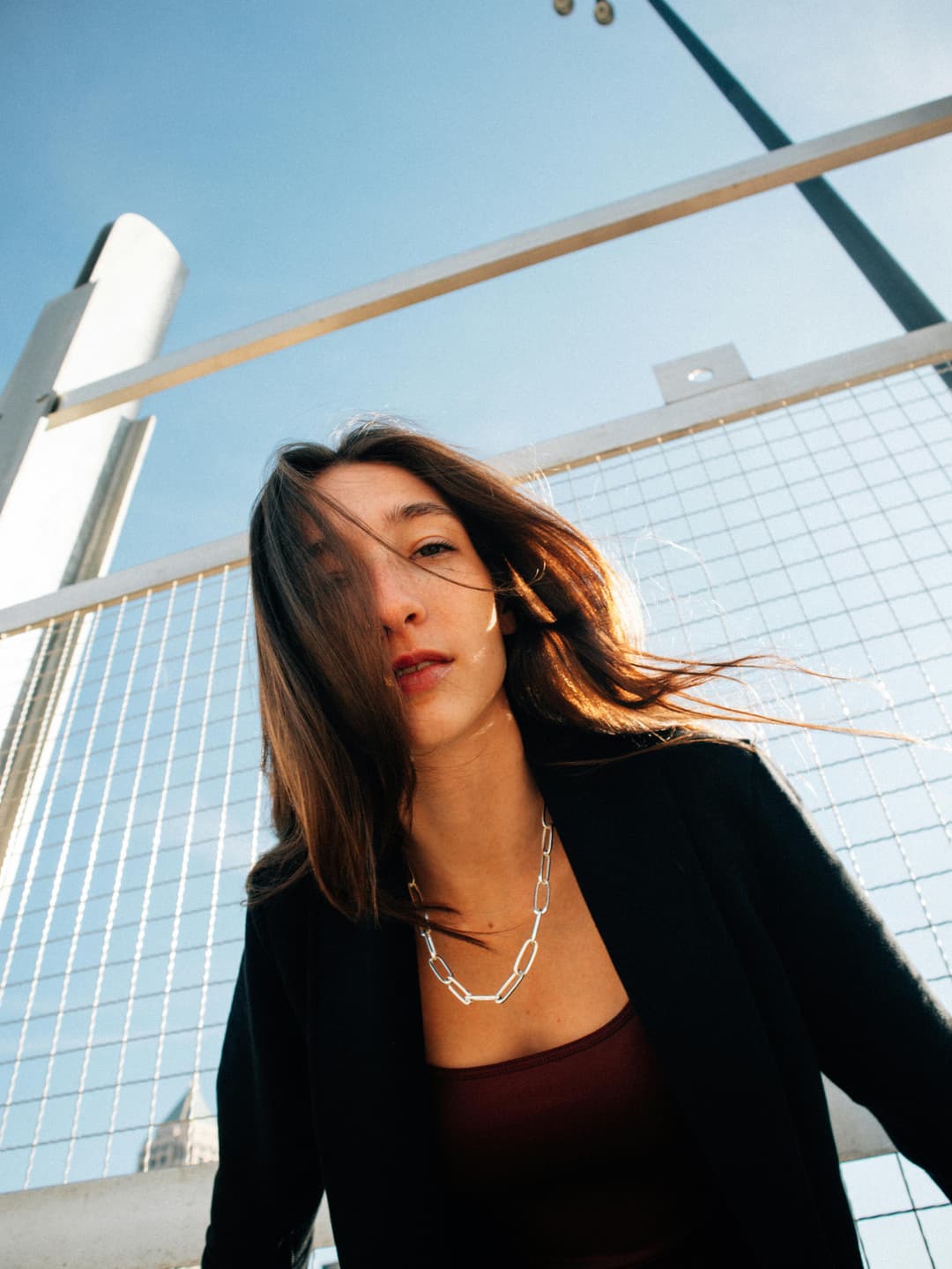Prowall Free Wallpaper | Stylish woman in black outfit posing outdoors against a city backdrop in Atlanta.