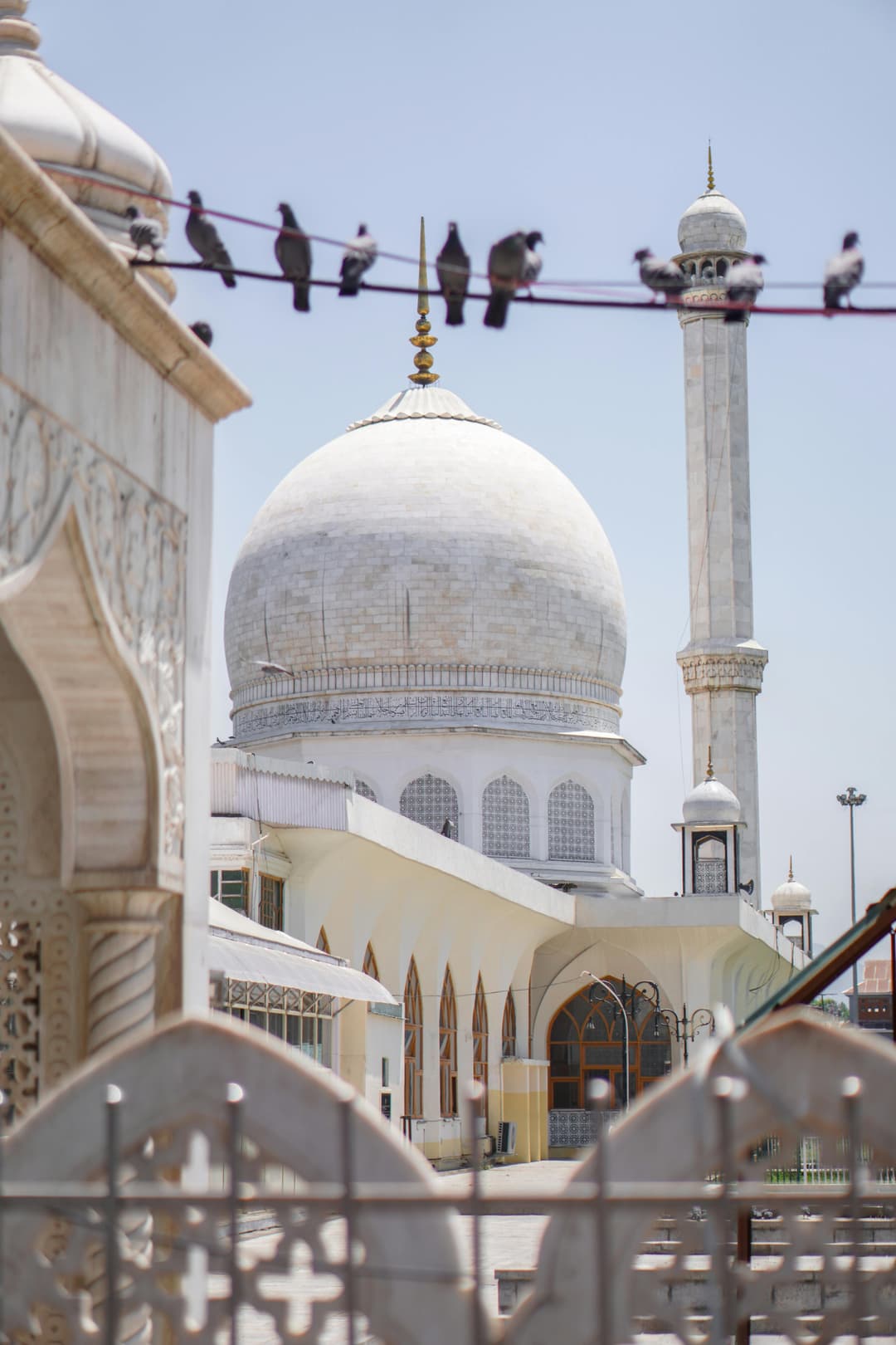 Prowall Free Wallpaper | Tranquil view of a mosque in Srinagar with a dome and minaret under a clear sky.