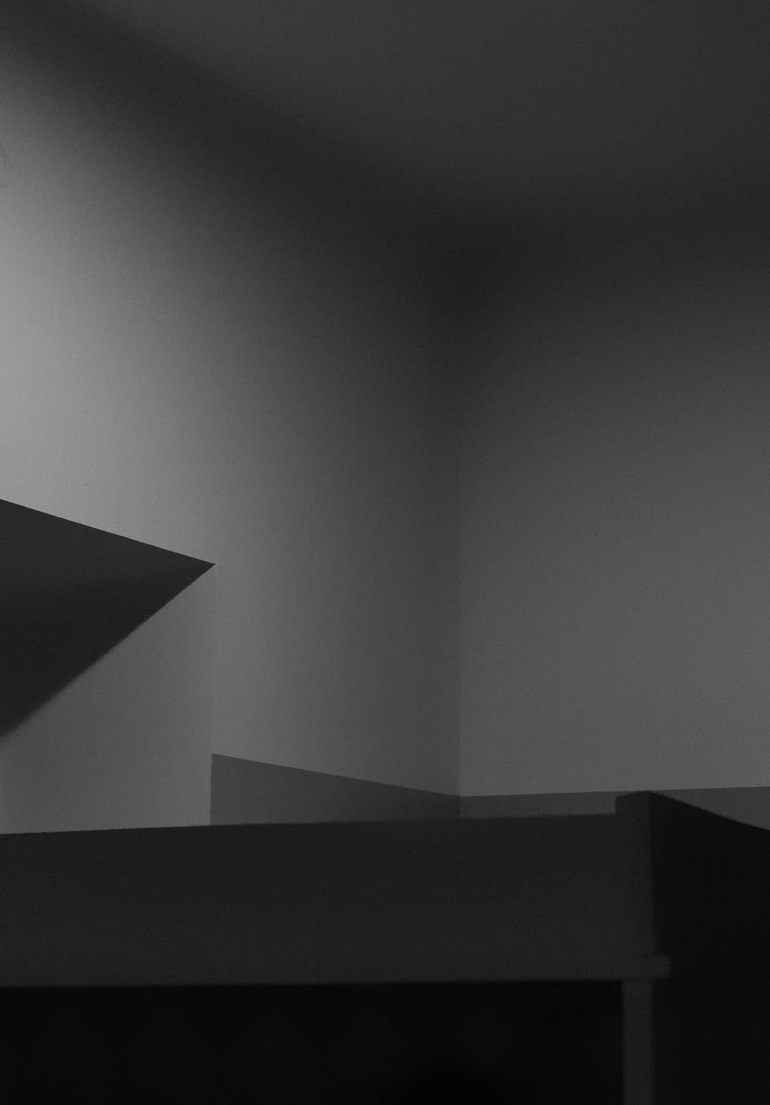 Prowall Free Wallpaper | A minimalist black and white photo highlighting architectural shadows and light play.