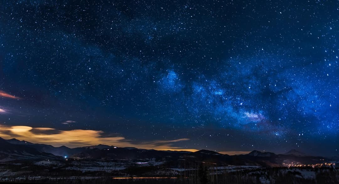 Prowall Free Wallpaper | A breathtaking view of the Milky Way galaxy illuminating the night sky over mountains.