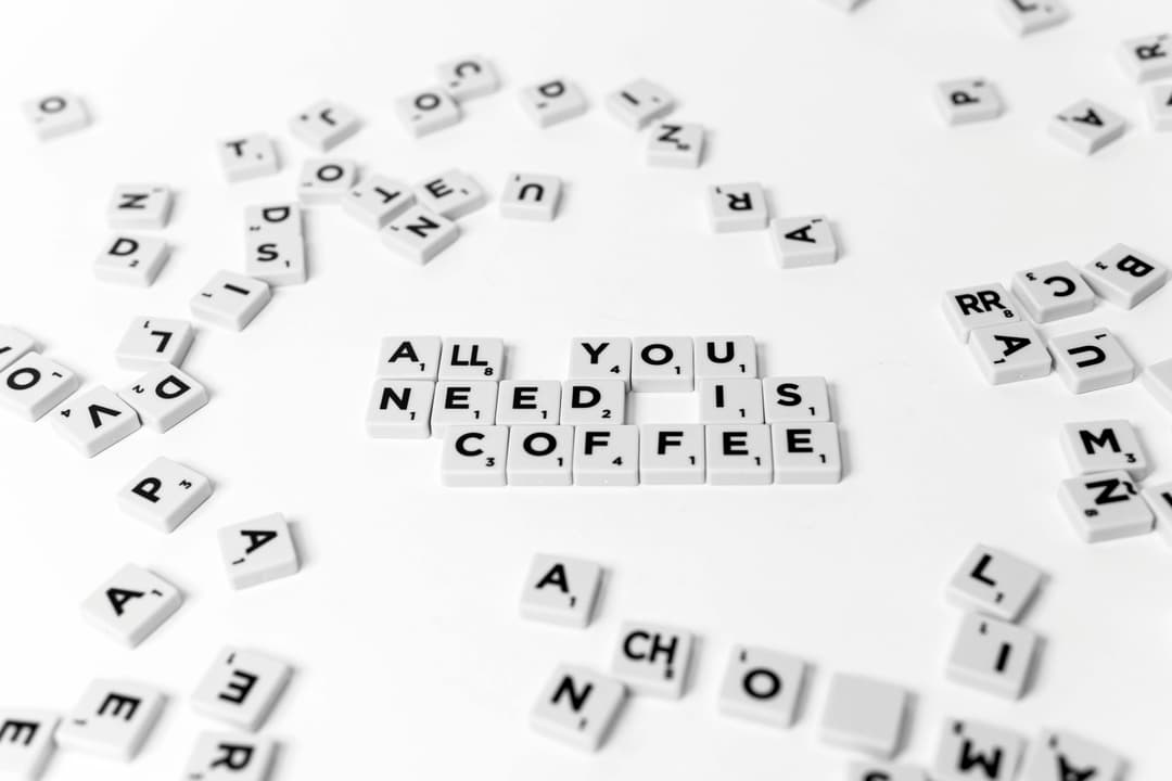 Prowall Free Wallpaper | Scrabble tiles spell out 'All You Need Is Coffee' on a white background, offering a creative still life.
