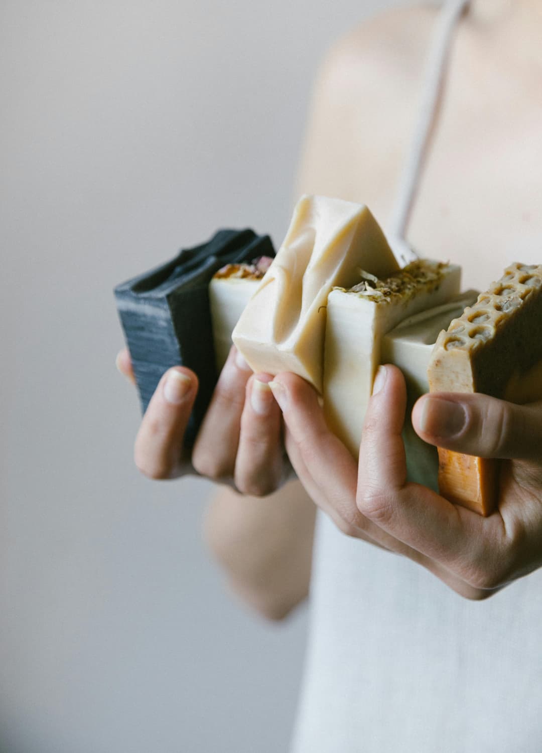 Prowall Free Wallpaper | Close-up of hands holding diverse organic soaps in a delicate skin care setting.
