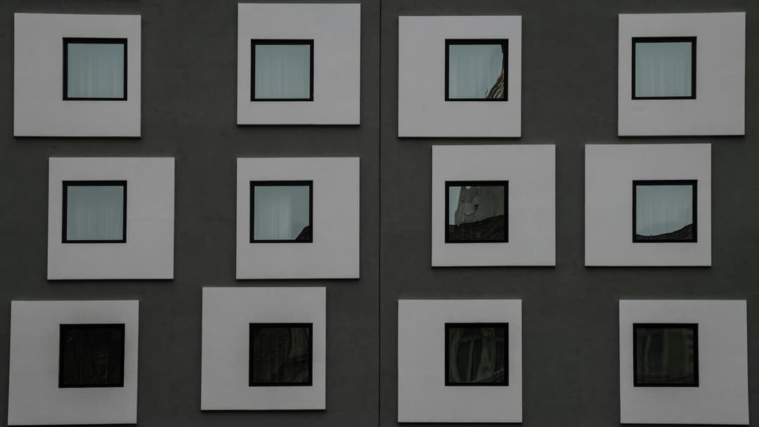 Prowall Free Wallpaper | A symmetrical facade with square windows on a modern building.