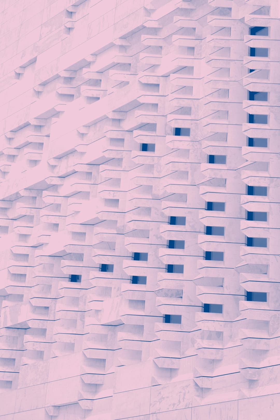 Prowall Free Wallpaper | Abstract pink-toned facade with geometric shapes and repetitive patterns.