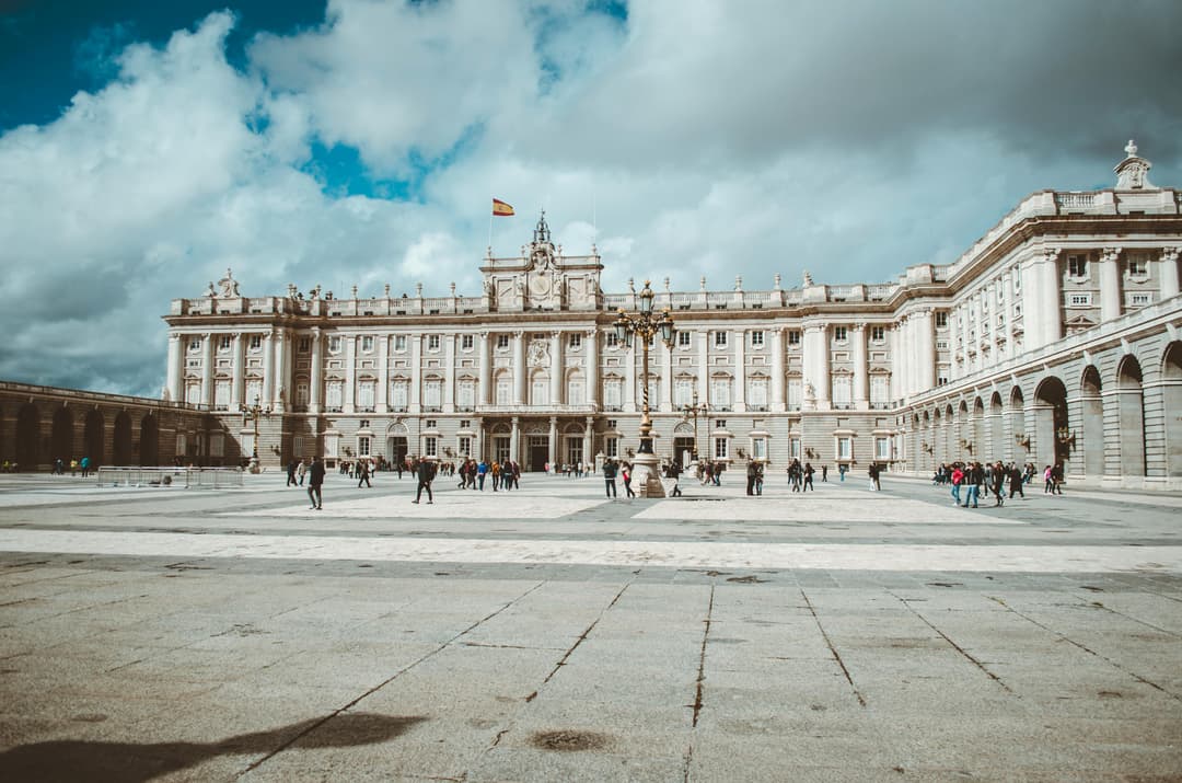 Prowall Free Wallpaper | The majestic Royal Palace of Madrid with tourists enjoying a cloudy yet beautiful day.