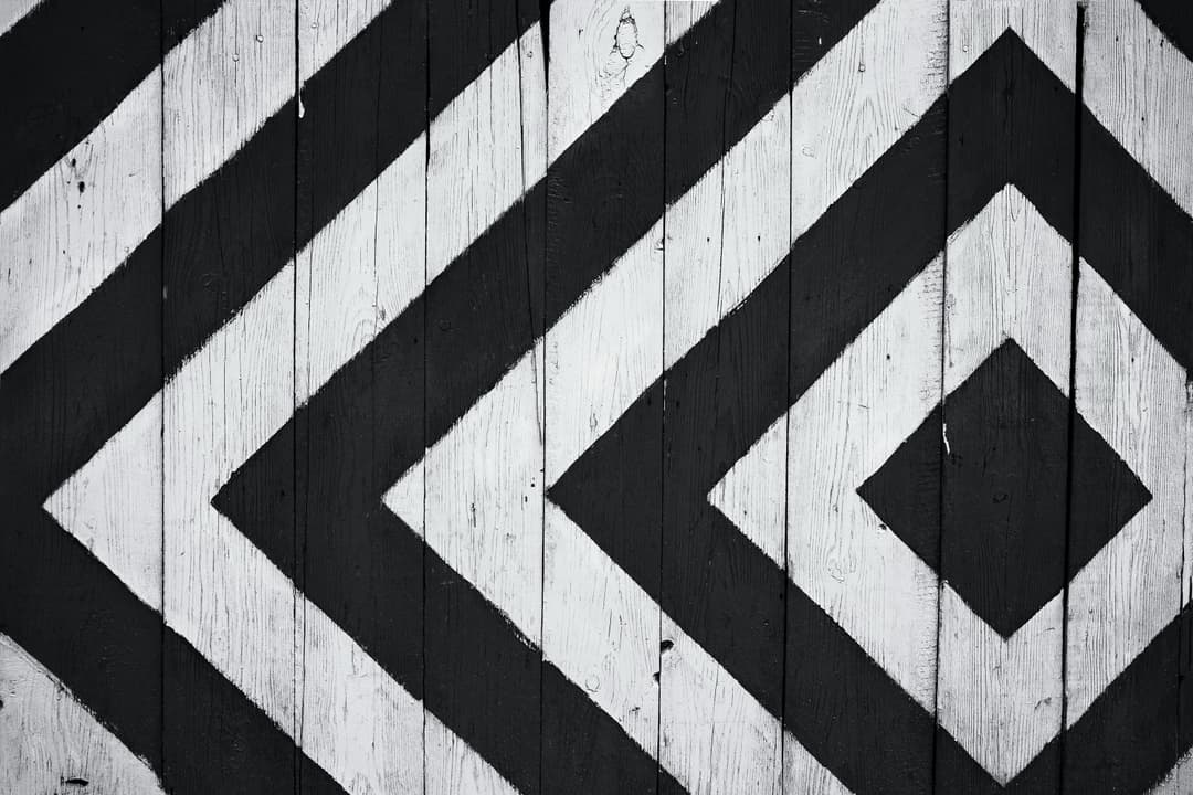 Prowall Free Wallpaper | Black and white geometric pattern on wooden planks, ideal for modern design backgrounds.